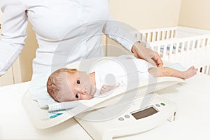 Woman weight cute newborn baby infant boy on scale