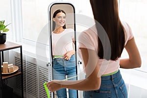 Woman After Weight Loss Measuring Waist In Front Of Mirror Indoor