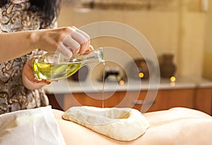 woman in wellness spa having aroma therapy massage with essential oil,Woman enjoying a Ayurveda oil massage treatment in