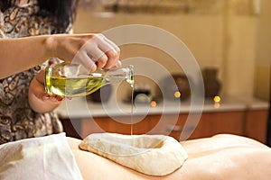 woman in wellness spa having aroma therapy massage with essential oil,Woman enjoying a Ayurveda oil massage treatment in