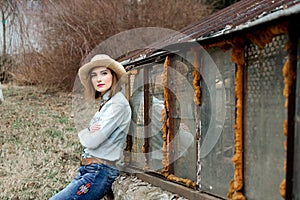 Woman in western wear in cowboy hat, jeans and cowboy boots.