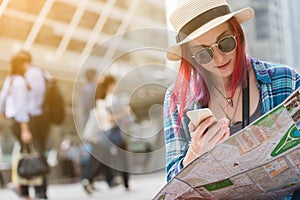 Woman westerner looking at map and smartphone during city tour i