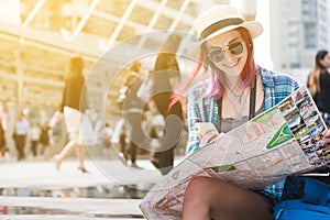 Woman westerner looking at map and smartphone during city tour i