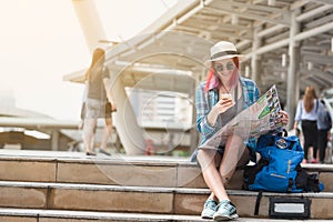 Woman westerner looking at map and smartphone during city tour i