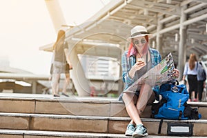 Woman westerner looking at map and smartphone during city tour i photo