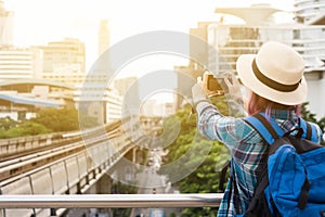 Woman westerner taking photo of sky train track in city in the m photo