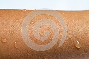 Woman wet arm with water drops on white acrylic background, Close up & Macro shot, Selective focus, Asian Body skin part