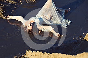 Woman in wet dress in water stream, vacation