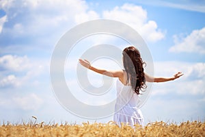 Woman in wheat field enjoying