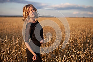 Woman in wheat field under blue sky