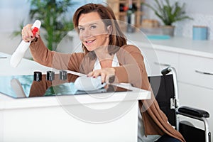 woman on wheelchair cleaning kitchen