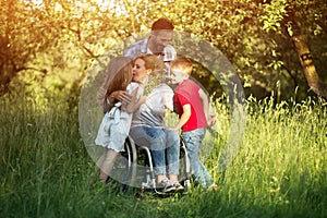 Woman in wheelchair kisses her son among family members