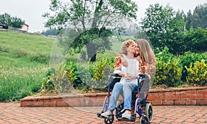 Woman in a wheelchair kissing her daughter