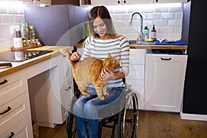 Woman in wheelchair in kitchen at home