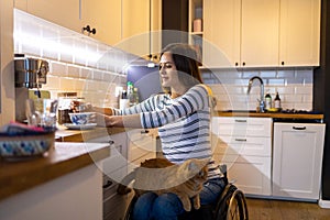 Woman in wheelchair in kitchen at home