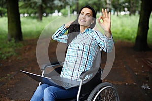 Woman in wheelchair show ok gesture with hand, work during rehabilitation photo
