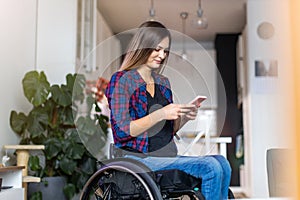 Woman In Wheelchair on Smartphone At Home
