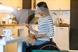 Woman In Wheelchair on Smartphone At Home