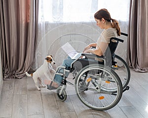 A woman in a wheelchair uses a laptop.