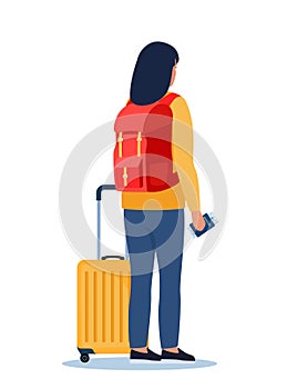 Woman with wheeled suitcase and backpack stand with passport and ticket in her hand. Passenger in airport stands with back half