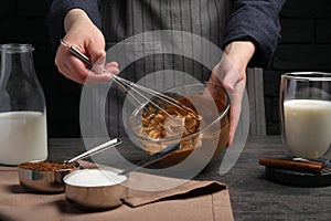 Woman whipping cream for dalgona coffee at grey table, closeup