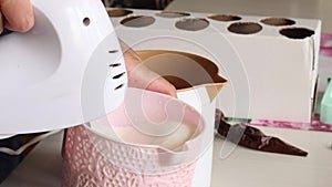 A woman is whipping cream with a submersible mixer. Makes homemade ice cream. Close-up