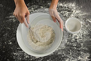 Woman whisking flour in bowl