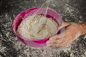 Woman whisking flour in bowl