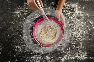 Woman whisking flour in bowl