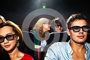 Woman Whispering In Boyfriend's Ear In Cinema Theatre
