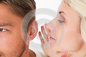 Woman whispering secret into a mans ear