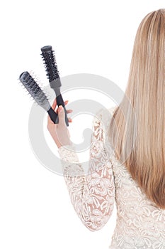 Woman on white background holding brushes and a hairdryer. Stock