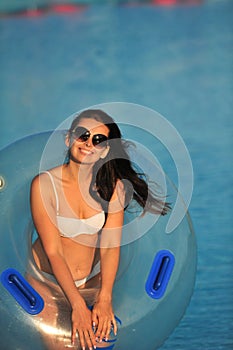 A woman in a white bathing suit with an inflatable circle in a water Park