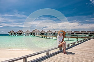 Woman in white on a beach jetty at Maldives