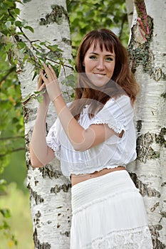 Woman in white by birch in summer