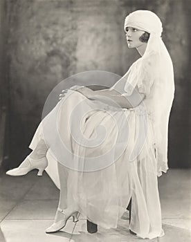 Woman in white chiffon dress and veiled turban