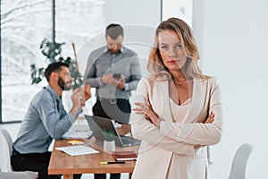 Woman in white clothes standing in front of her employees. Group of business people that working on the project in the office