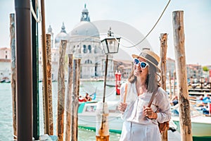 woman in white clothes with straw hat at pier basilica santa maria della salute on background