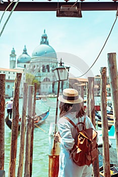 woman in white clothes with straw hat at pier basilica santa maria della salute on background