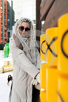 Woman With White Dreadlocks Standing Next to Yellow Post