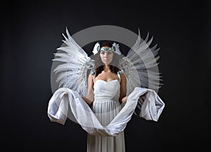 Woman in white dress with angel wings.