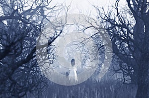 Woman in white dress with the boy walking in haunted forest