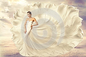 Woman White Dress, Fashion Model in Long Silk Waving Gown, Flying Fluttering Fabric on Wind photo