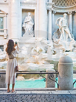 Woman in white dress in front of Trevi Fountain in Rome