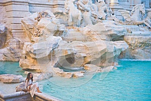 Woman in white dress in front of Trevi Fountain in Rome