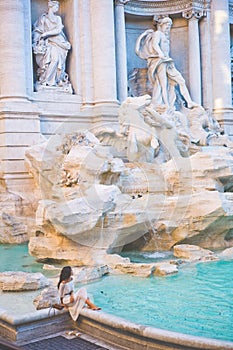 Woman in white dress in front of Trevi Fountain in Rome