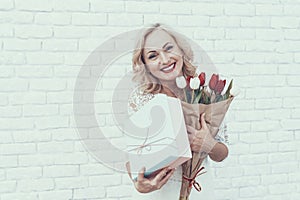 Woman in White Dress with Gift Box and Bouquet.