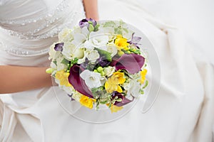 Woman in a white dress holding her wedding flowers