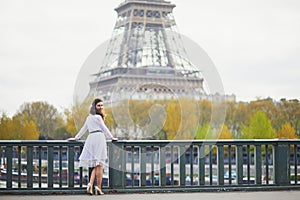 Woman in white dress near the Eiffel tower in Paris, France