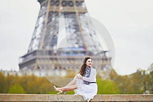 Woman in white dress near the Eiffel tower in Paris, France